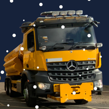 A photo of a yellow gritting vehicle. 