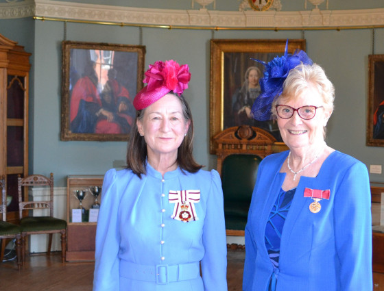 Two ladies wearing their medal honours