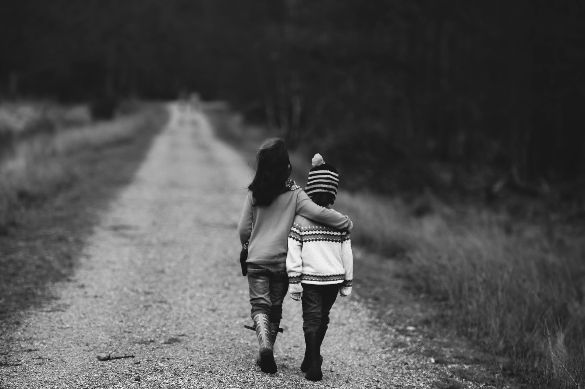 Two children walking along a quiet road