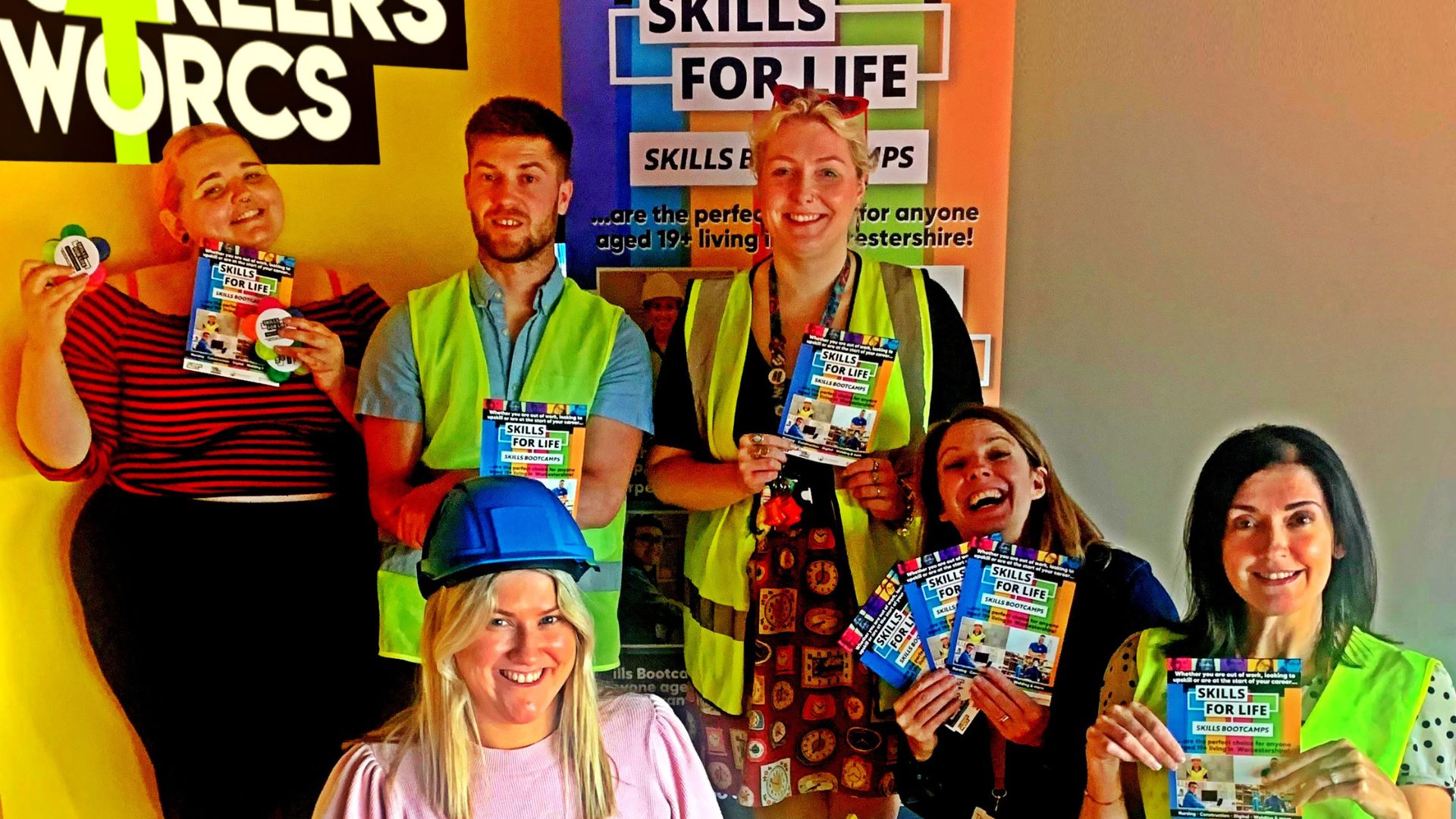 People hold skills bootcamps leaflets in front of a Careers Worcs banner