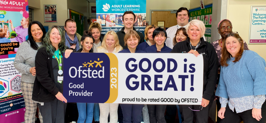 Staff and learners at Adult Learning and Young Adult Learning stand in a group facing the camera holding a large banner that reads "GOOD is GREAT, proud to be rated good by OFSTED"