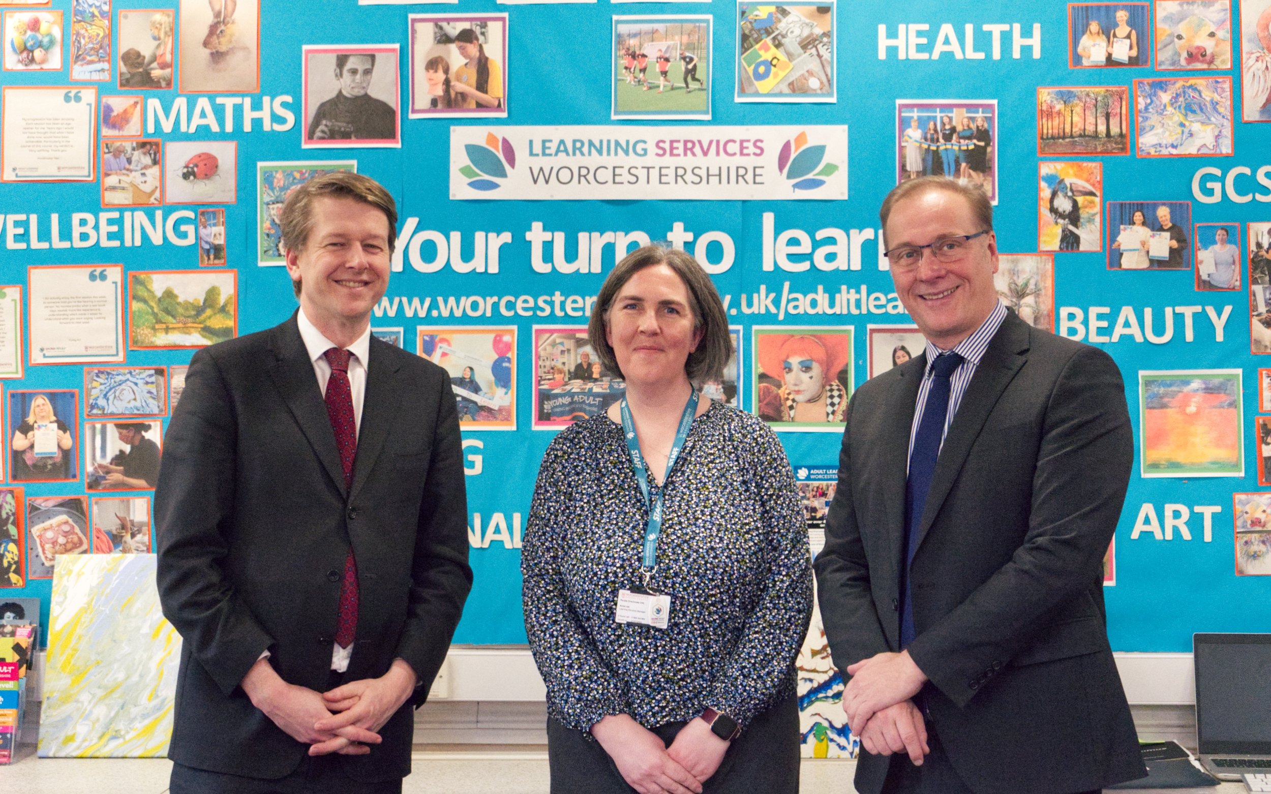 Robin Walker MP, Anna Lee and Councillor Marc Bayliss stand in front of a Creative Studies display wall at the Fairfield Learning Centre. Image taken by Young Adult Learning Worcestershire student Oli Louch.