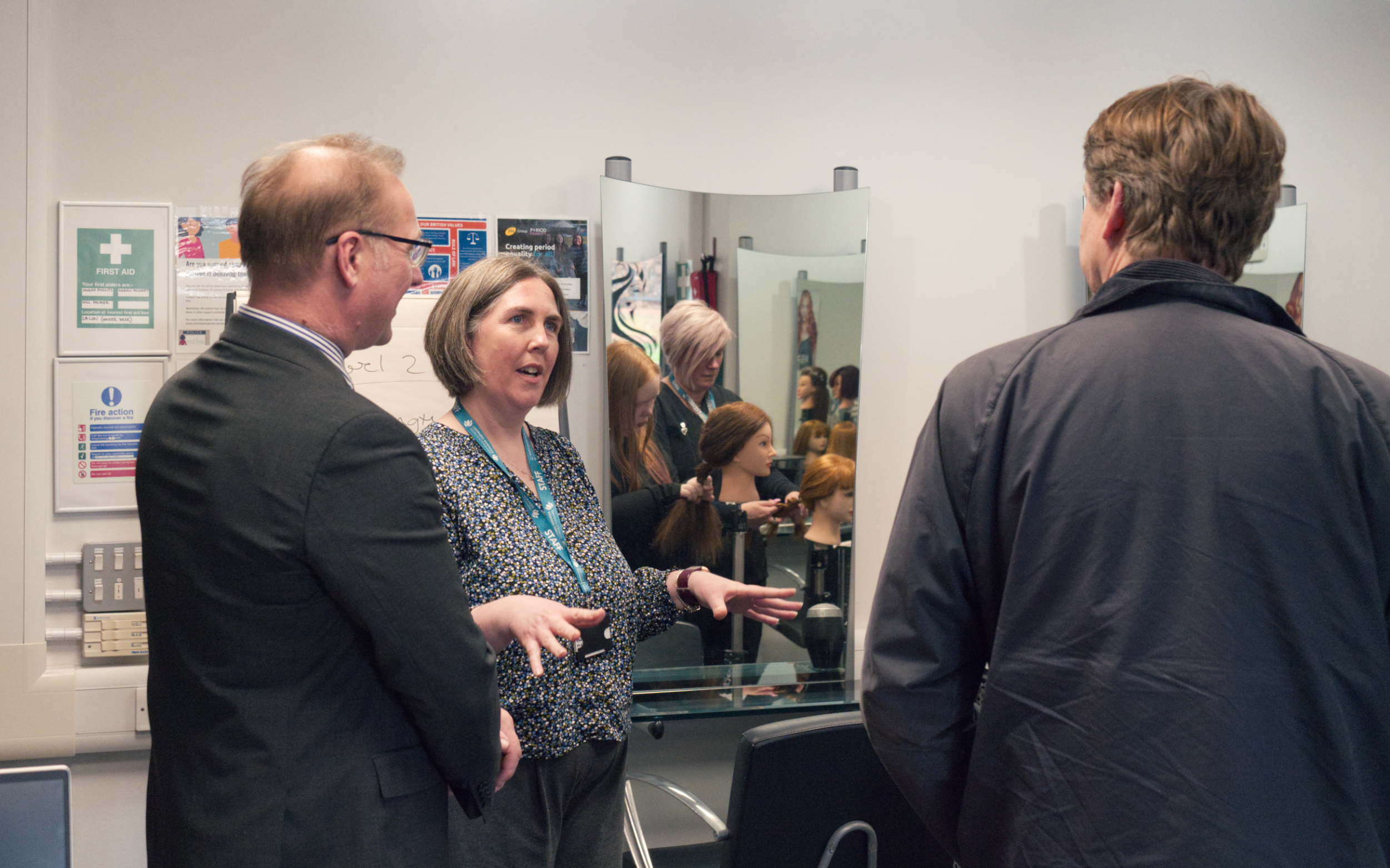 Councillor Marc Bayliss, Anna Lee & Robin Walker MP talk in Fairfield Learning Centre Hair Salon while a learner is seen working in a mirrors reflection. Image taken by Young Adult Learning Worcestershire student Oli Louch.