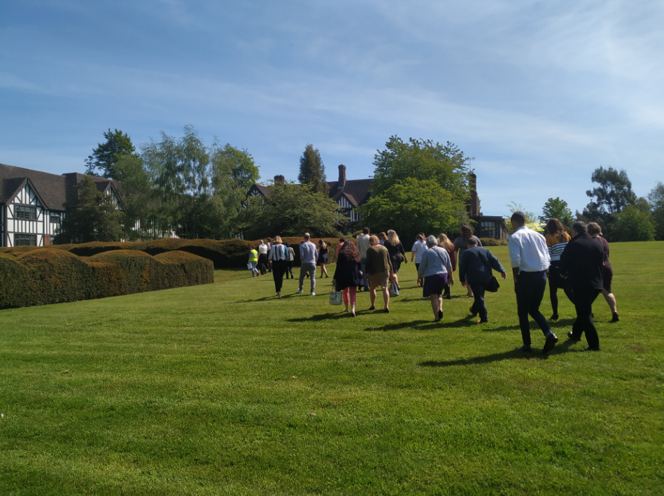 Back view of people walking across a lawn