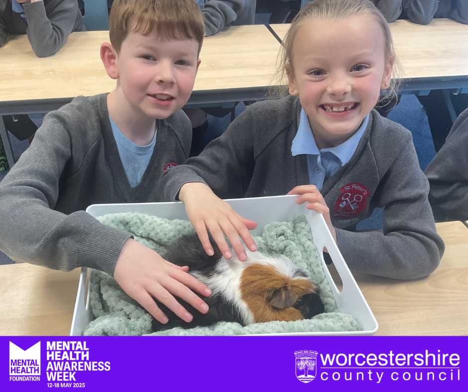 two school children petting a new therapy guinea pig
