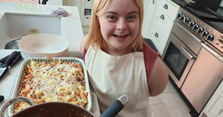 Young person smiling in the kitchen making food