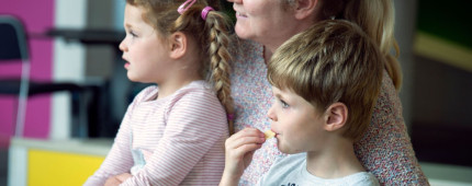 Mother sitting on the floor with her two children on her lap smiling