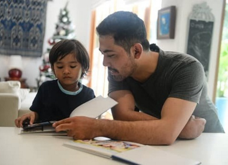 A man and boy reading a book together