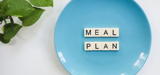 Scrabble letters spelling out meal plan on a plate