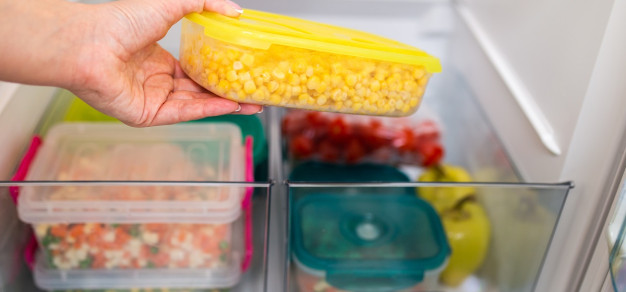 Person putting items into a freezer in sealed containers