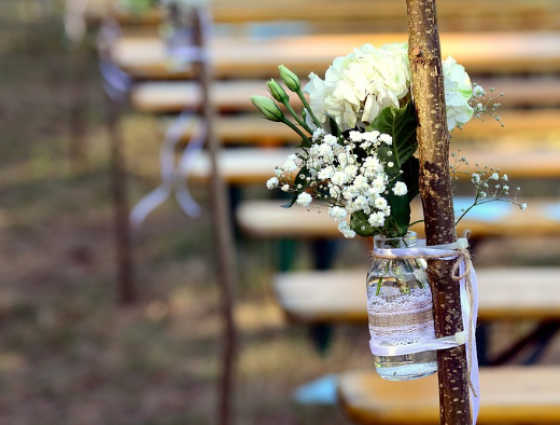 posy of flowers tied to a pole in front of decorated tables