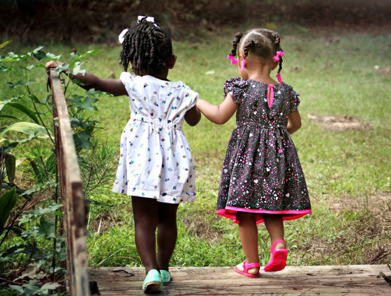 Two young girls walking and holding hands