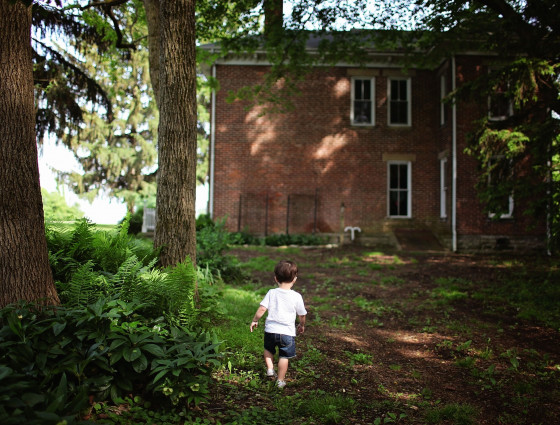 A boy alone outside a house