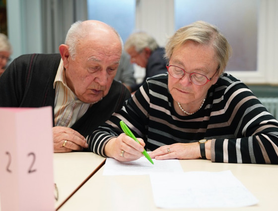 two older people filling in some paperwork
