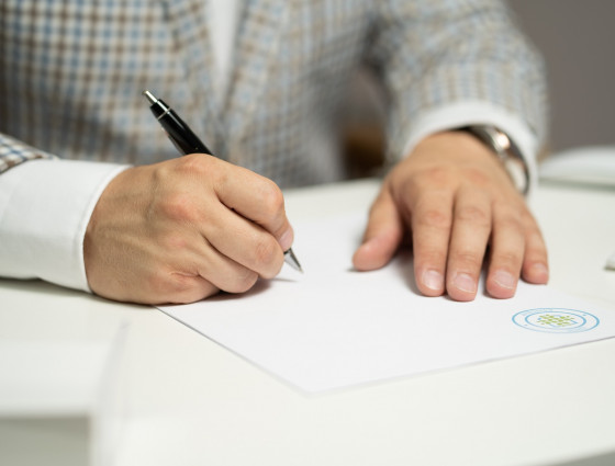 A man filling in a paper document with a pen