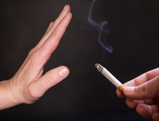 A cigarette being offered to someone and there hand is indicating no or stop