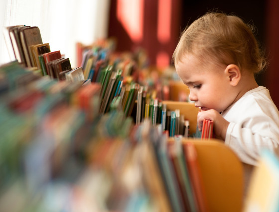 Young toddler browsing books in the children's library