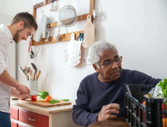 Carer in the kitchen sat with older person