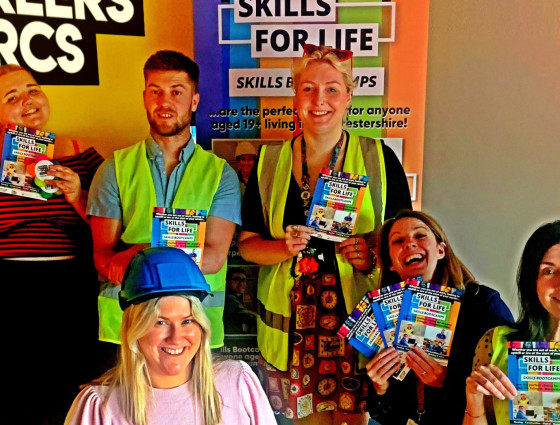 People hold skills bootcamps leaflets in front of a Careers Worcs banner