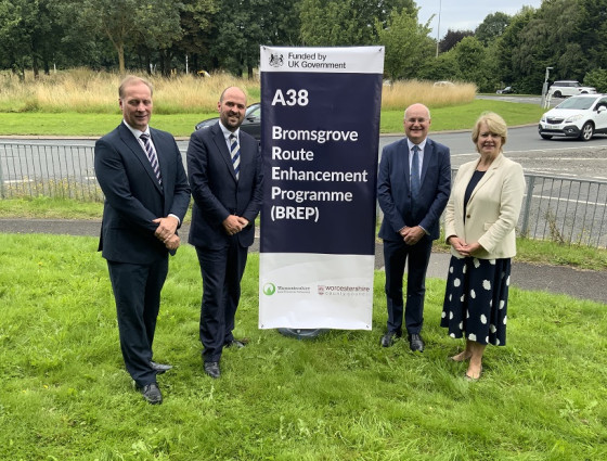 Four councillors stood by an A38 stand to celebrate the funding.