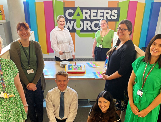 The Careers Worcs Team pose with a cake in front of the Careers Worcs banner