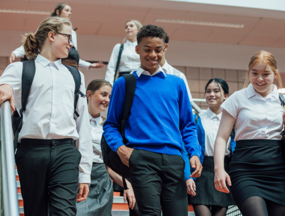 Teenagers in school uniform walking down stairs