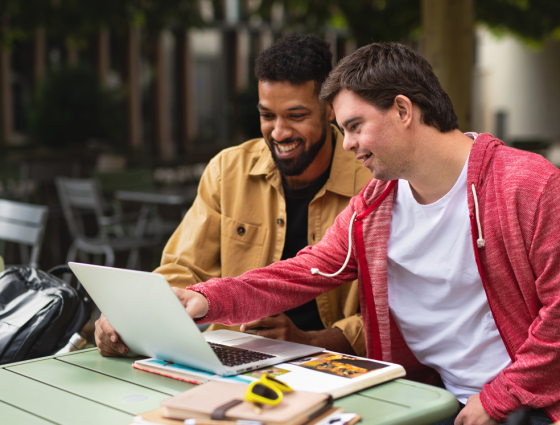 two people pointing at a computer