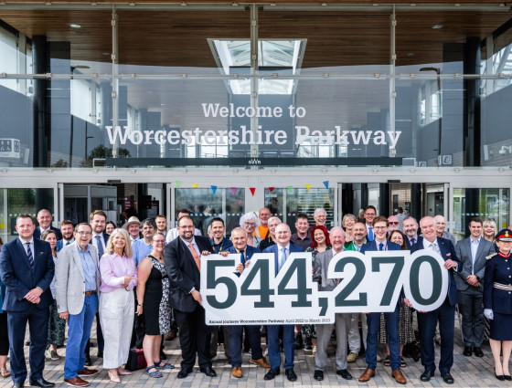 Guests pose with a banner outlining the number of Parkway passengers