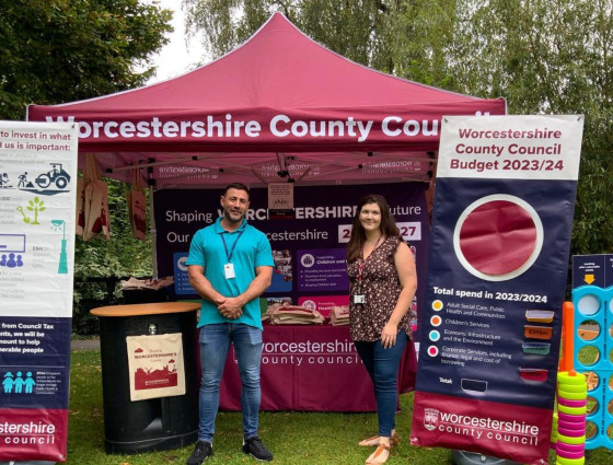Two staff members stand in front of the WCC gazebo at a Resident Roadshow