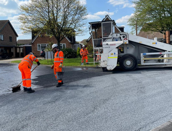 Contractors resurfacing a road