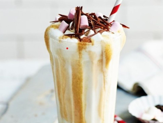 Tall glass with milkshake topped with chocolate
