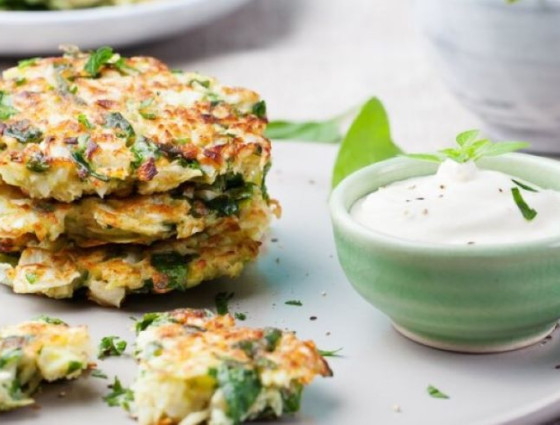 Plate of fritters next to a bowl with a dip in