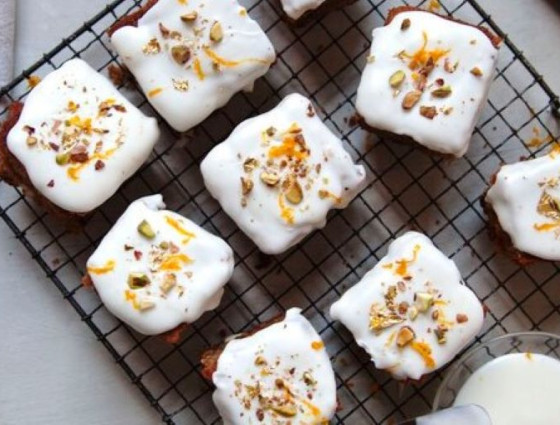 Squares of cakes with icing & nuts & orange rind on top