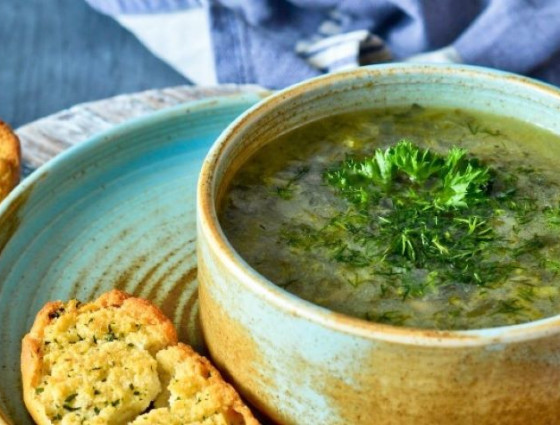 Bowl of soup with lettuce on top 