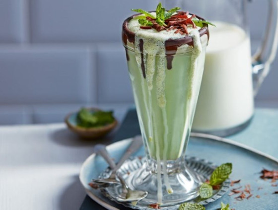 Tall glass with milkshake topped with chocolate