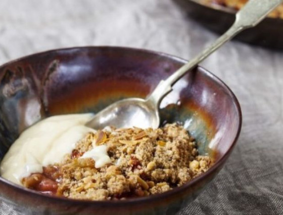 Bowl of crumble with custard & a spoon