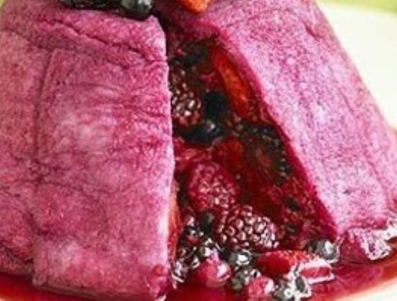 Summer pudding with slice removed to show fruit inside