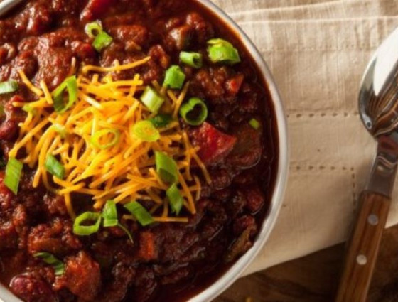 Bowl of chilli with cheese & spring onions on top