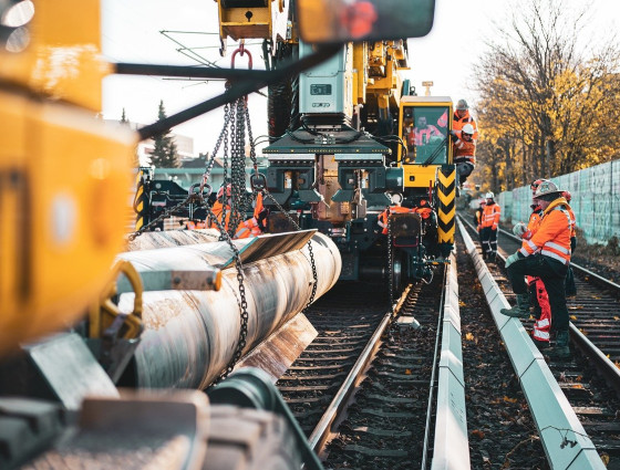Image of workers repairing train tracks with machinery