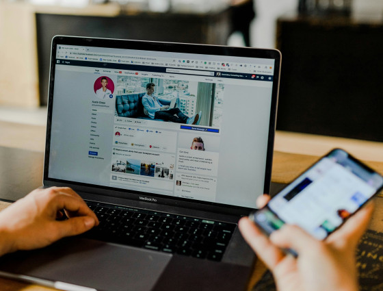 Image of a person using a laptop and phone to browse social media