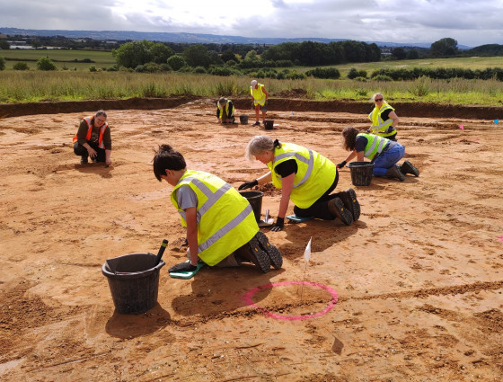 Three people doing an archaeology dig