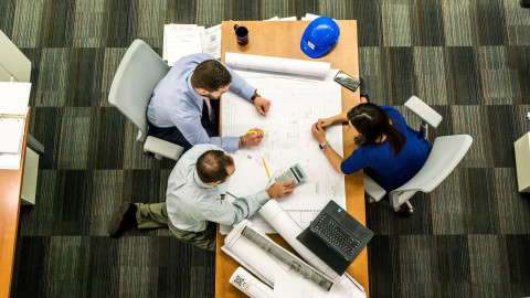 Three people around a table having a business meeting