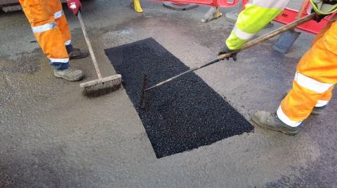 Photograph of a pothole being resurfaced. 