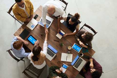 Aerial view of a table of people with two shaking hands