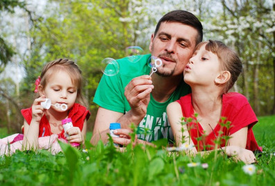 A father and daughters blowing bubbles