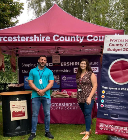 Two staff members stand in front of the WCC gazebo at a Resident Roadshow