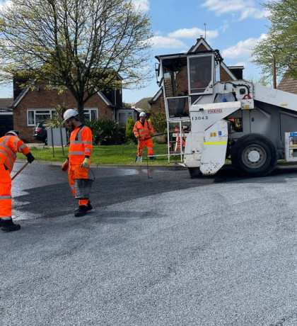 Contractors resurfacing a road