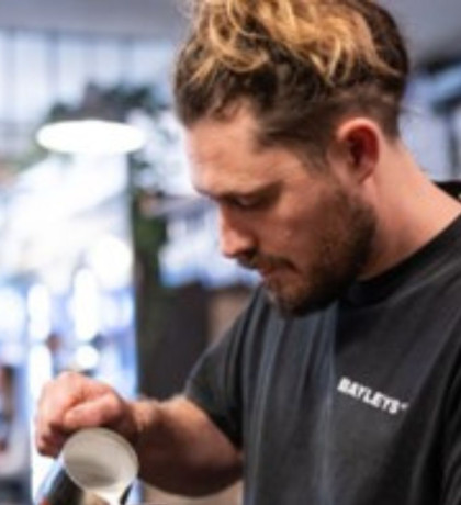 A man pouring a coffee in Bayley's coffee house. 