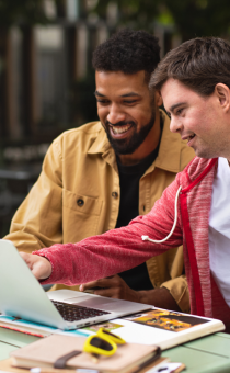 two people pointing at a computer