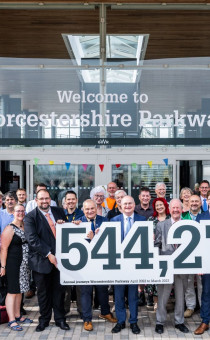 Guests pose with a banner outlining the number of Parkway passengers